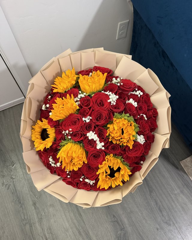 Girasol y Rosas by Blooms x Mel — Red roses studded with bright sunflowers and baby's breath in a cream wrap