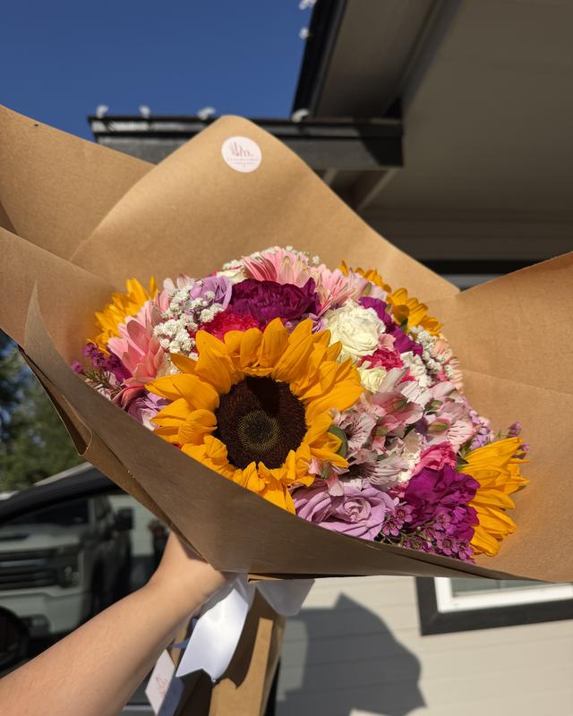 Golden Hour by Blooms x Mel — Sunflowers with roses, gerberas, alstroemeria, and wax flower in a kraft paper wrap