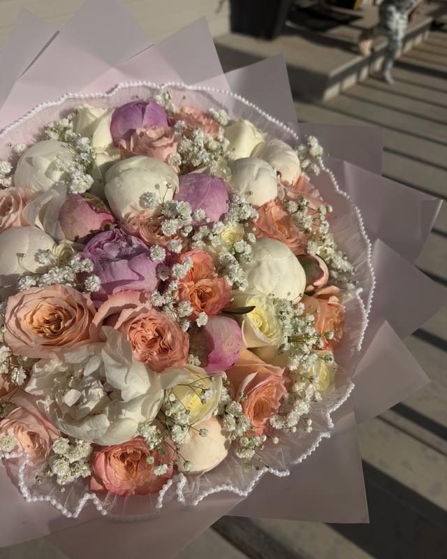La Perla by Blooms x Mel — White and lavender peonies with peach garden roses and baby's breath, finished in a pearl-trimmed wrap