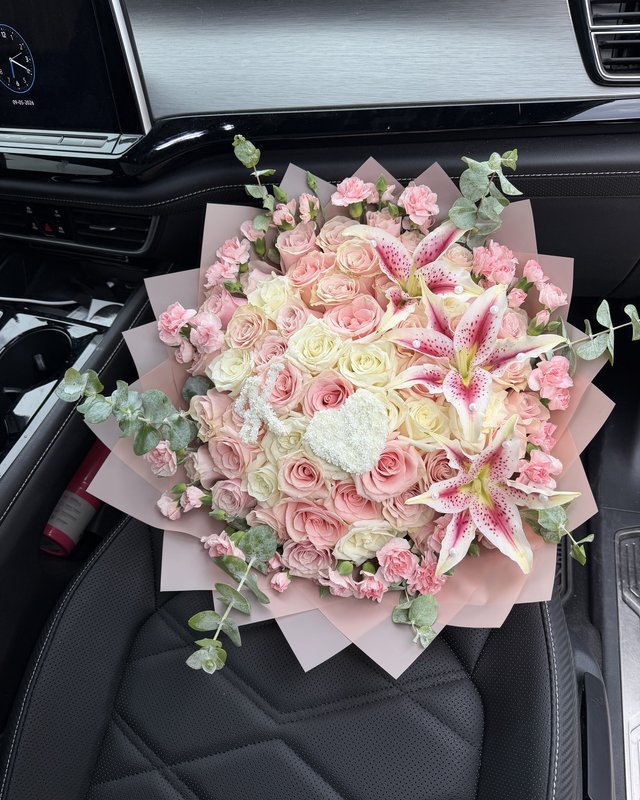 La Princesa by Blooms x Mel — Pink and ivory roses under stargazer lilies, ringed in mini carnations and eucalyptus, with a baby's breath heart