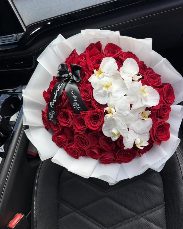 Orquídea by Blooms x Mel — Red roses topped with fresh white phalaenopsis orchids and a black satin bow