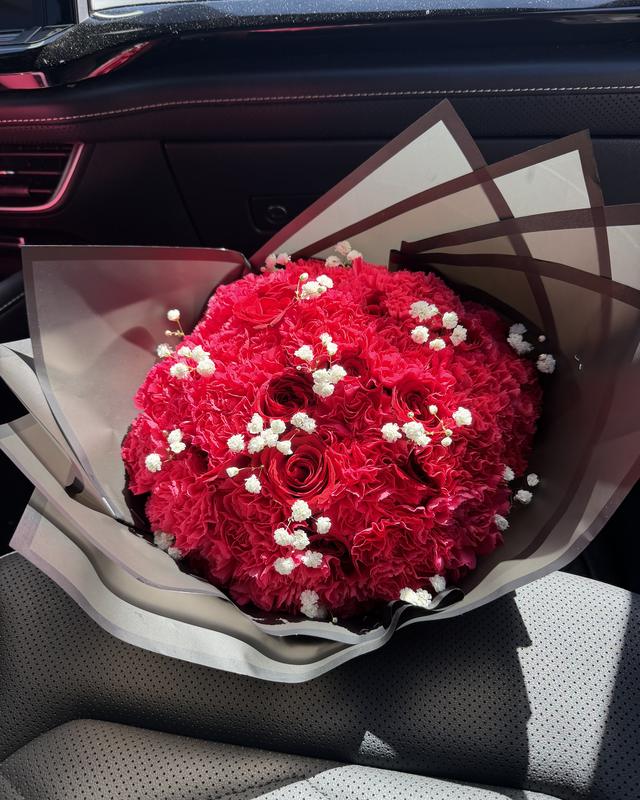 Rojo Dulce by Blooms x Mel — Red carnations and roses dotted with baby's breath in a black wrap