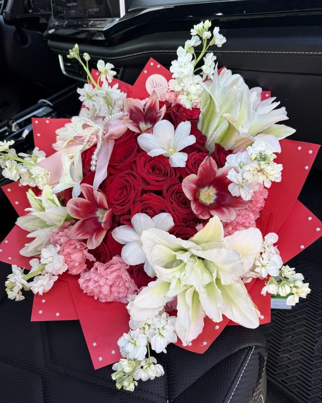 Rojo Romance by Blooms x Mel — Red roses ringed with pink carnations, white stock, lilies, and open tulips, finished with a pearl bow